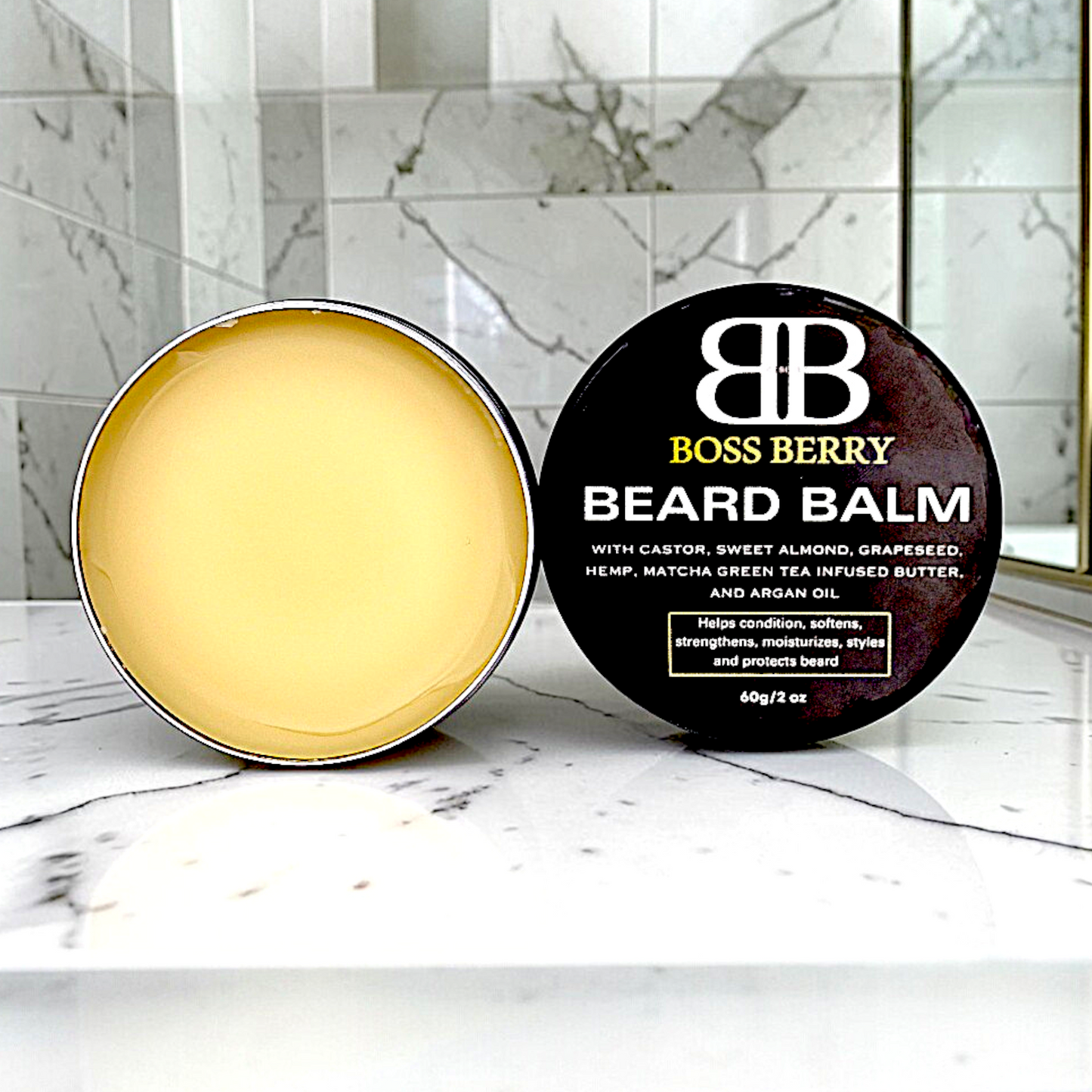 Two containers of Boss Berry beard balm on a marble surface with a blurred background.